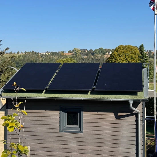 AIKO Balkonkraftwerk in der Praxis – drei Solarmodule auf dem Dach eines Gartenhauses