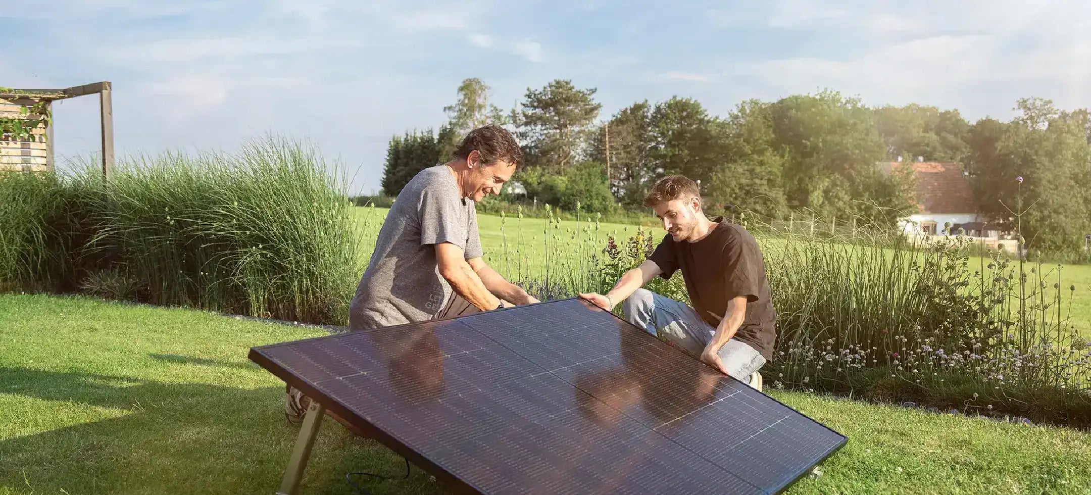 Zwei Männer stellen ein Solarmodul auf.
