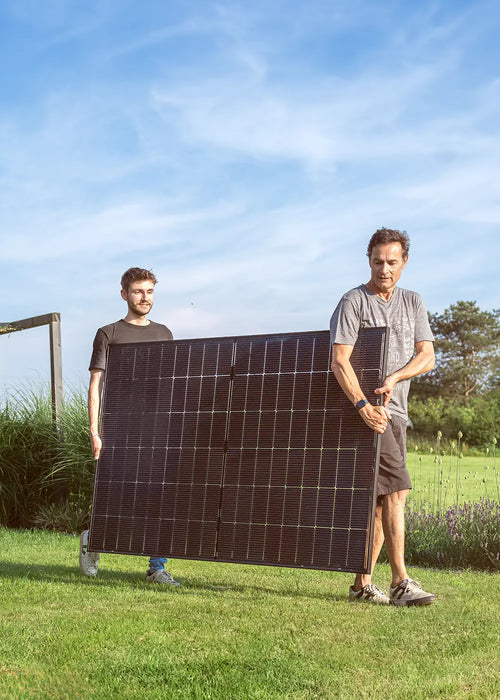 Zwei Männer tragen ein Solarmodul